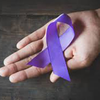 Hand holds a purple ribbon.