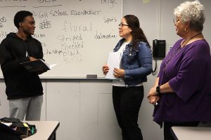 Two students in discussion with teacher.